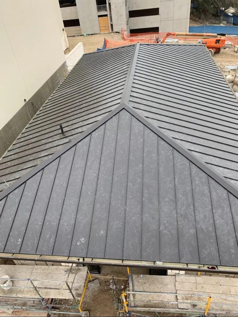 Commercial metal roof construction with crane equipment in Sutton